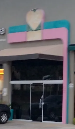 Entrada da Luxo de Pet: porta de vidro com moldura rosa e turquesa
